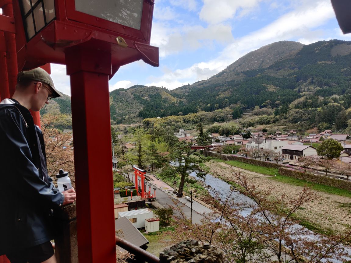 Me looking down at the village of Tsuwano from a hill through a torii gate