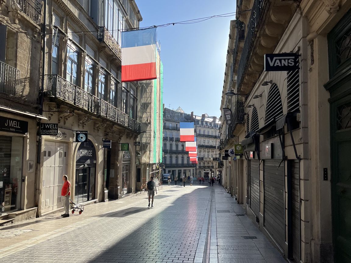 French flag hanging between buildings in Montpellier